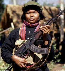 A female Khmer Rouge fighter or 'mit naree' carries an AK-47 assault rifle, a weapon of Communist revolution the world over.